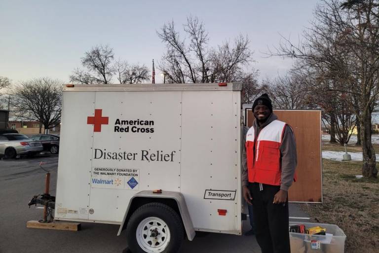 Man stands next to Red Cross disaster relief trailer