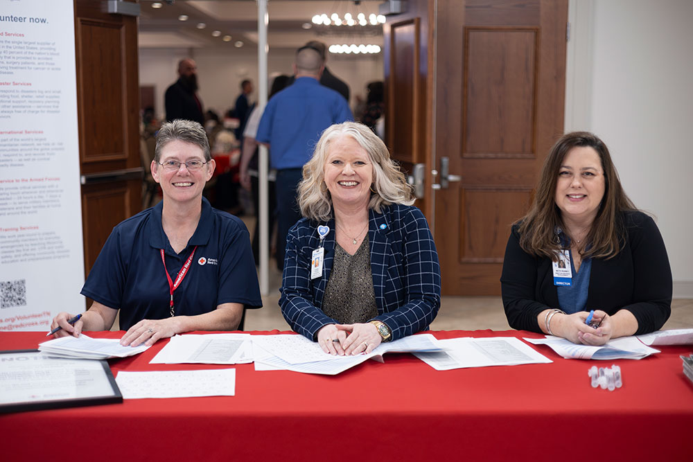 three Red Cross employees at check-in table for the Mid-West Tennessee Heroes Luncheon.
