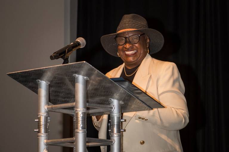 Woman smiling at podium with mic