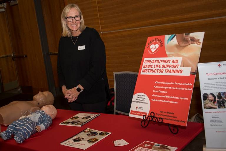 red cross volunteer at table with cpr mannequins 