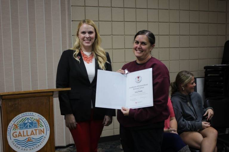Two women stand with lifesaving award