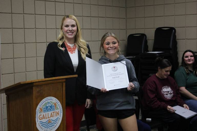 Two women stand with lifesaving award