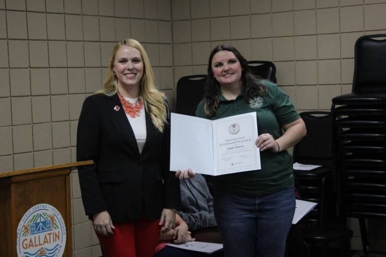 Two women stand with lifesaving award