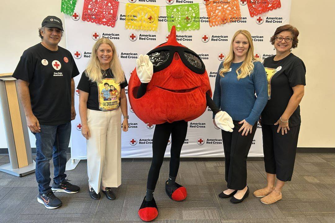 Group of people stand with buddy the blood drop