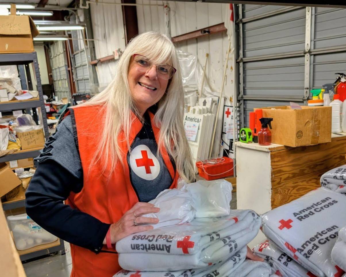Woman organizes Red Cross blankets in warehouse