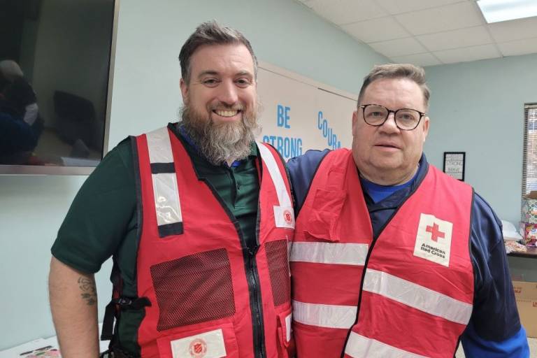 Two men wearing Red Cross vests 