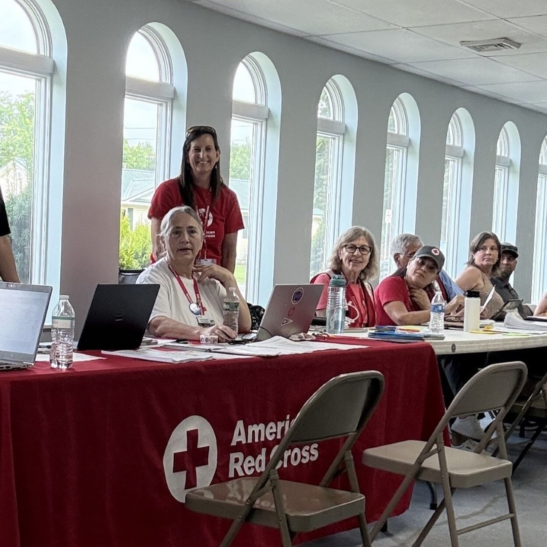 group of red cross volunteers behind table