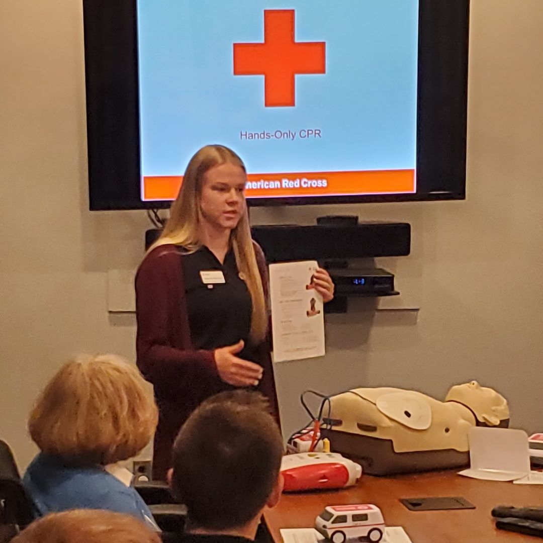 woman holding flyer while talking to group