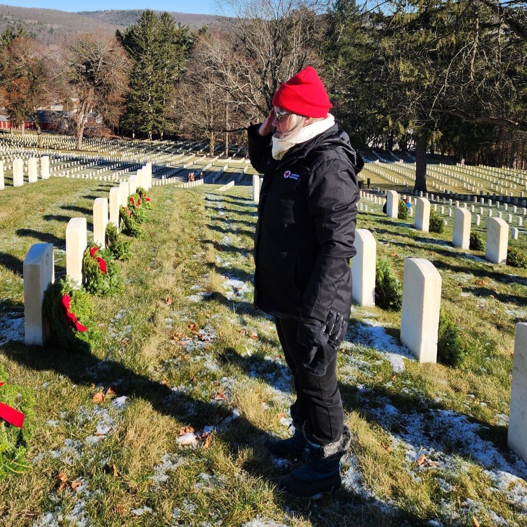 woman salutes tombstones 