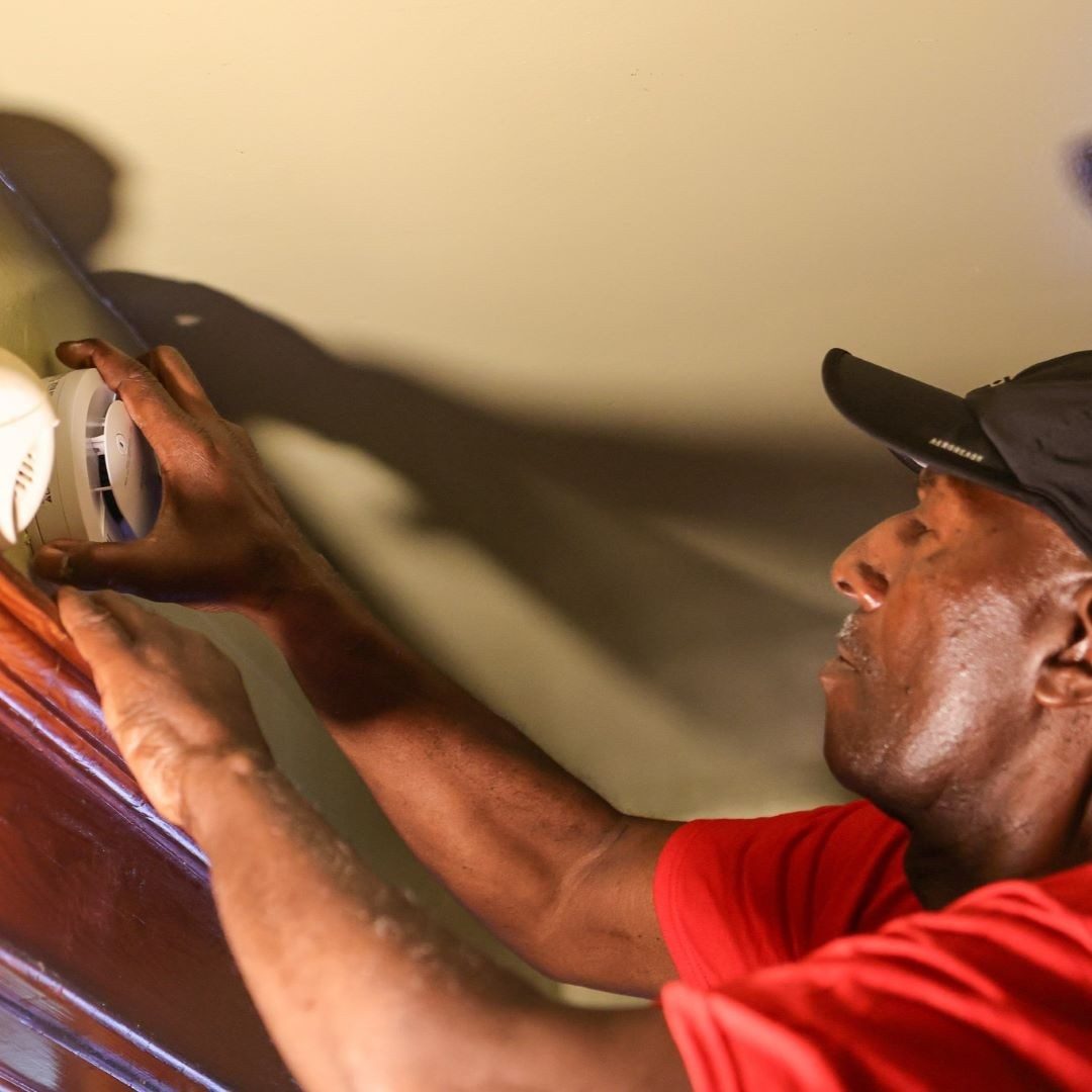 Red Cross volunteer installing smoke alarm