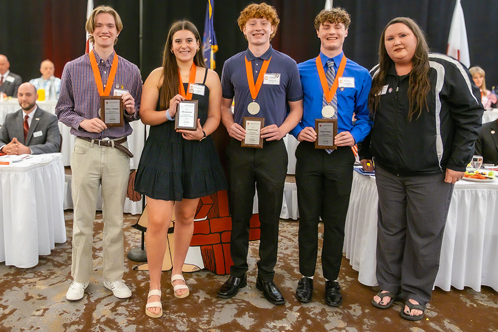four good neighbor heroes hold up their awards at the Real Heroes Event.