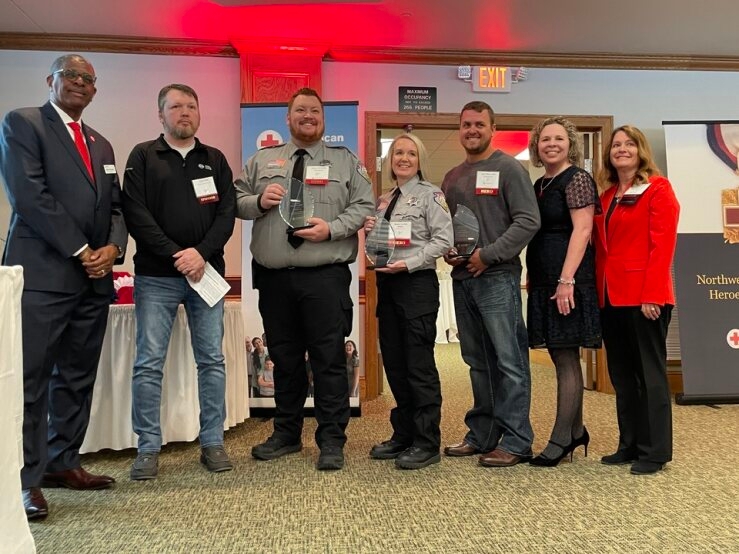 Group of people wearing mask posing with awards