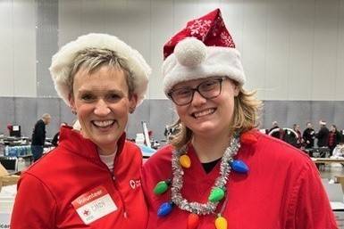 Two women wear holiday gear at a blood drive