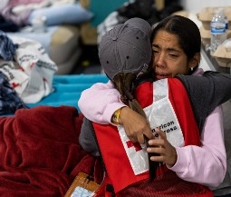person gets food from red cross volunteer