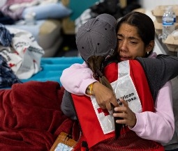 person gets hug from red cross volunteer