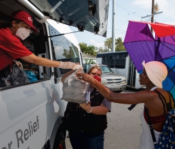 person gets food from red cross volunteer