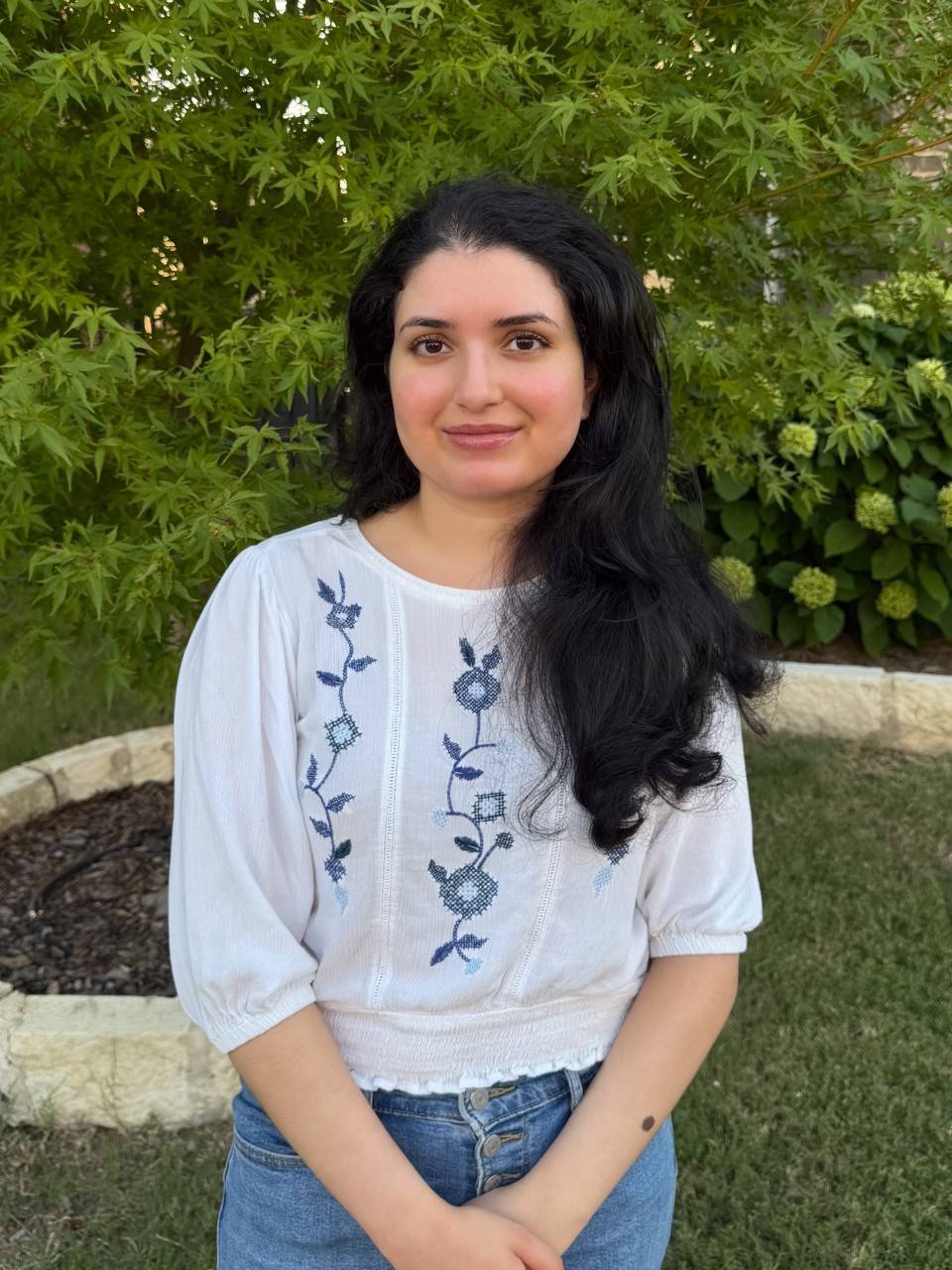 Shreya Jupelly , a young woman wearing a white and blue blouse, with dark brown hair. 