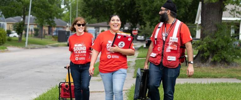 Red Cross volunteers walking getting ready to install smoke alarms.