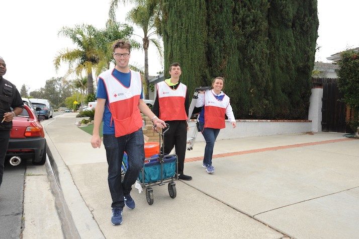 Group of volunteers pulling a wagon with smoke alarms to be installed