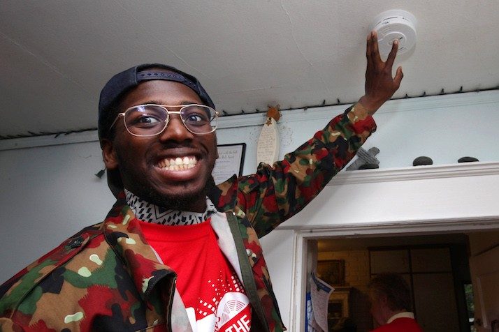 Young man testing smoke alarm in home