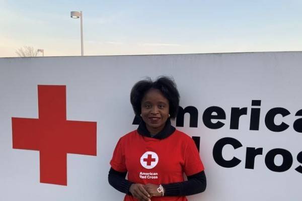 Funmi Afonja standing in front of the American Red Cross sign.
