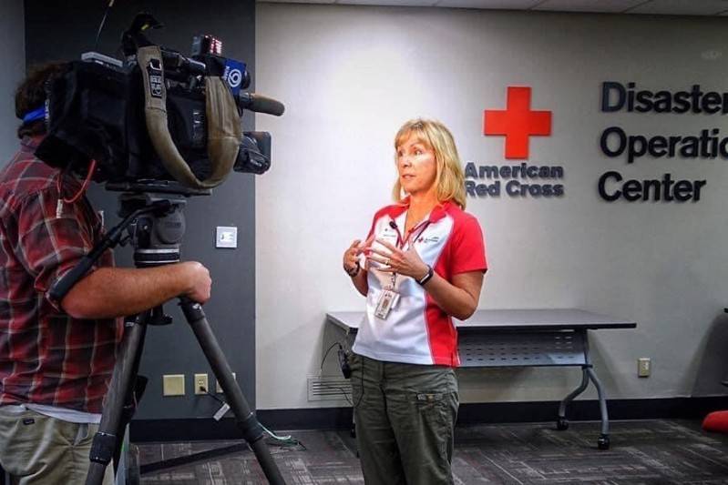 Sherri O'dell in front of a camera at the Red Cross Disaster Operation Center.