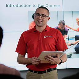 An American Red Cross instructor speaking in front of a group of employees.