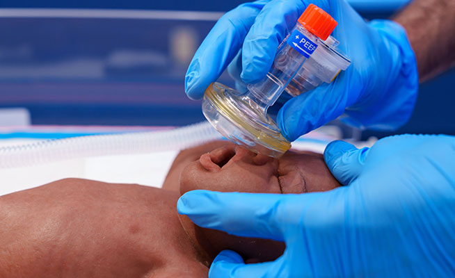 Medical professional applying neonatal resuscitation techniques.