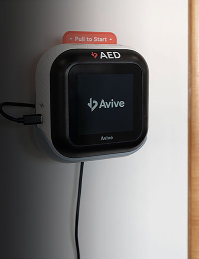 Avive Connect AED front with pull to start tab in office.