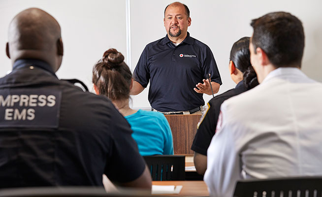 Red Cross Instructor teaching a group of EMTs about Basic Life Support.