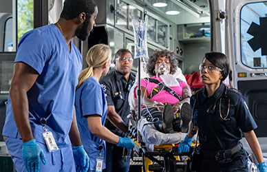 Emergency responders preparing a patient with an oxygen mask for ambulance transport, coordinating urgent care at the back of the vehicle during a critical medical situation.