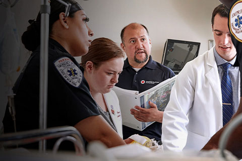 Red Cross Instructor teaching healthcare innovations from the Red Cross Resuscitation Suite to a paramedic, physicians and clinical staff in a hospital setting.