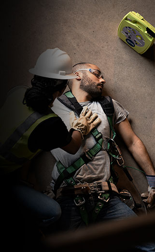 Construction worker performing CPR on a coworker.