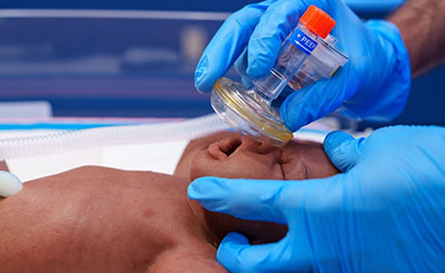 Medical professional applying neonatal resuscitation techniques.