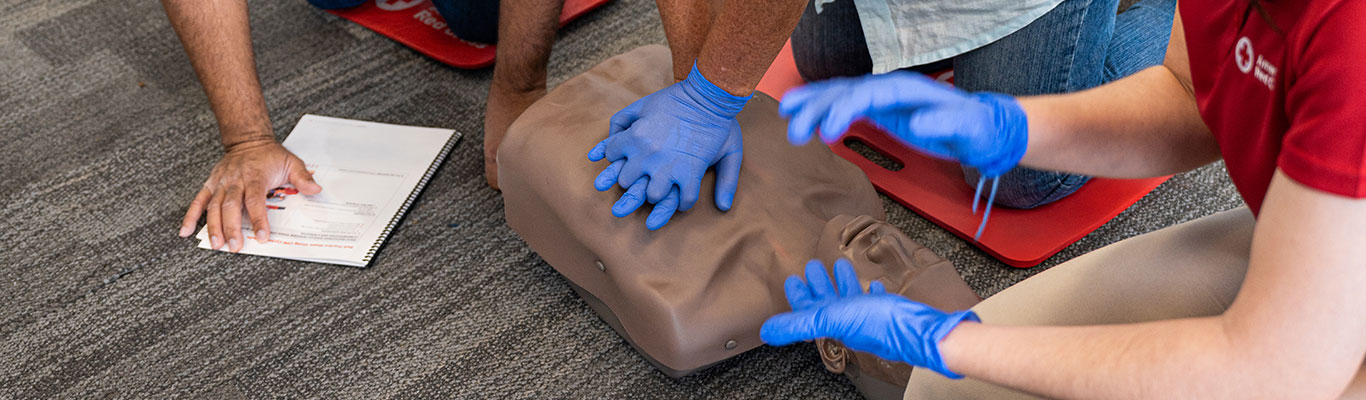 An instructor keeping rhythm during CPR compression training.
