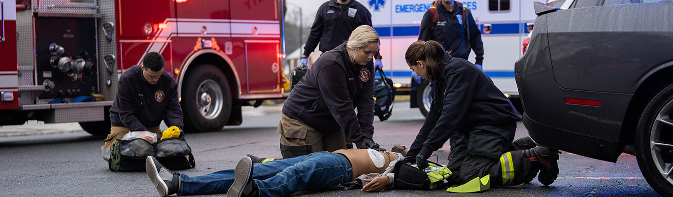 EMS professionals using an AED on someone experiencing a medical emergency.