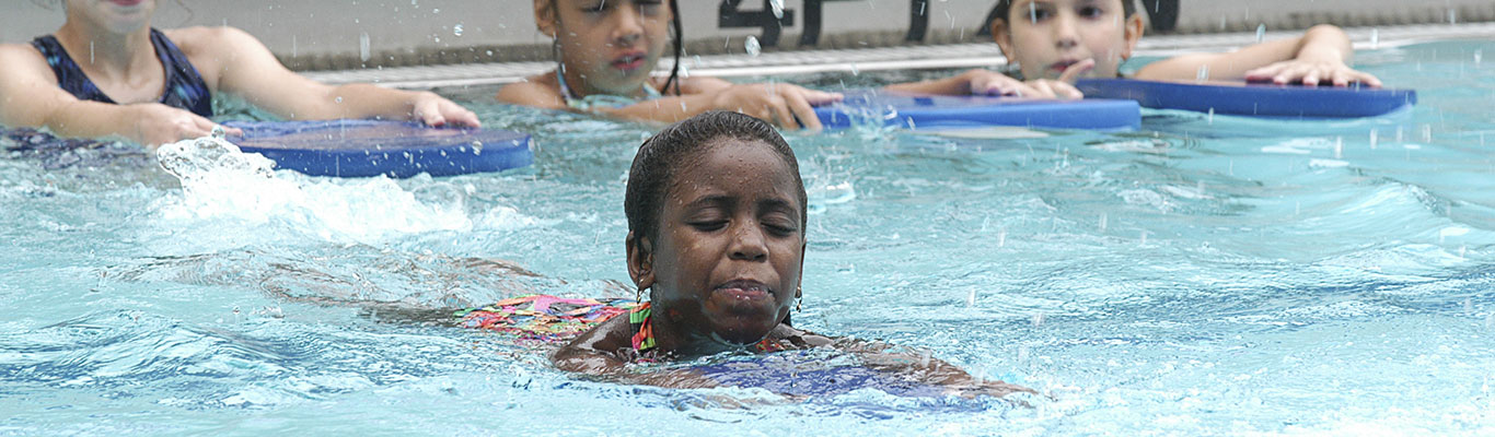 Child swimming in shallow water at pool.