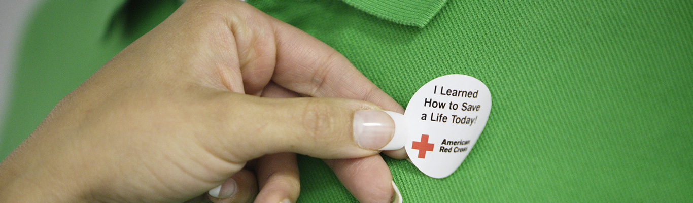 First Aid Class Participant Wearing a Red Cross Sticker with Text Saying I Learned How to Save a Life Today.
