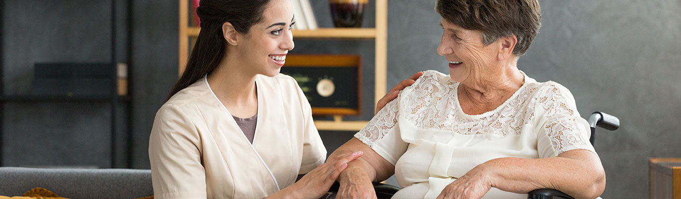 Certified Nursing Assistant (CNA) communicating with a patient.
