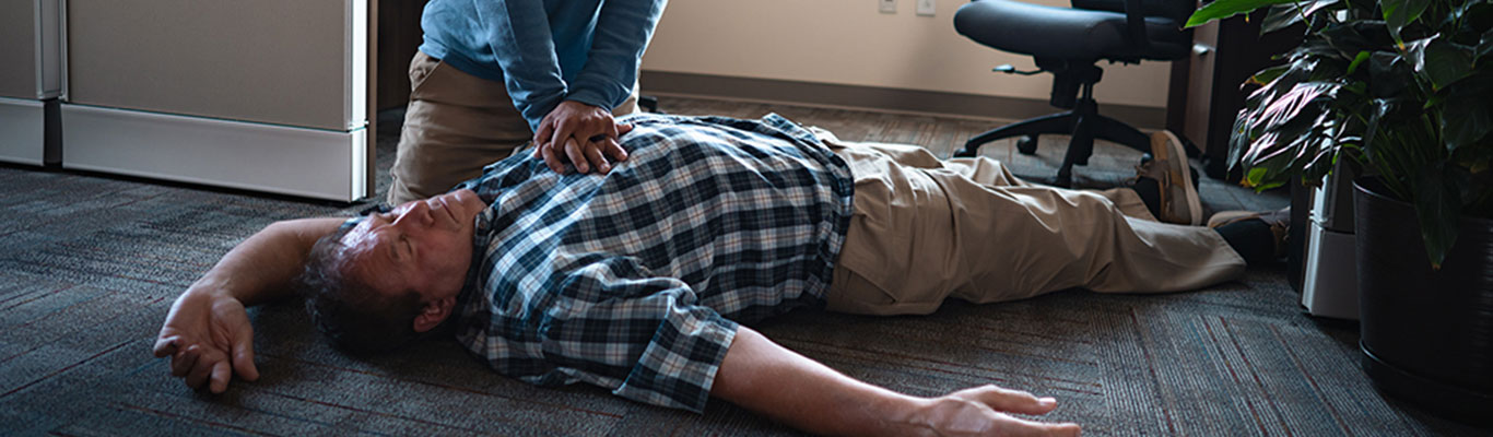 Man performing Hands-Only CPR to another person on the floor.