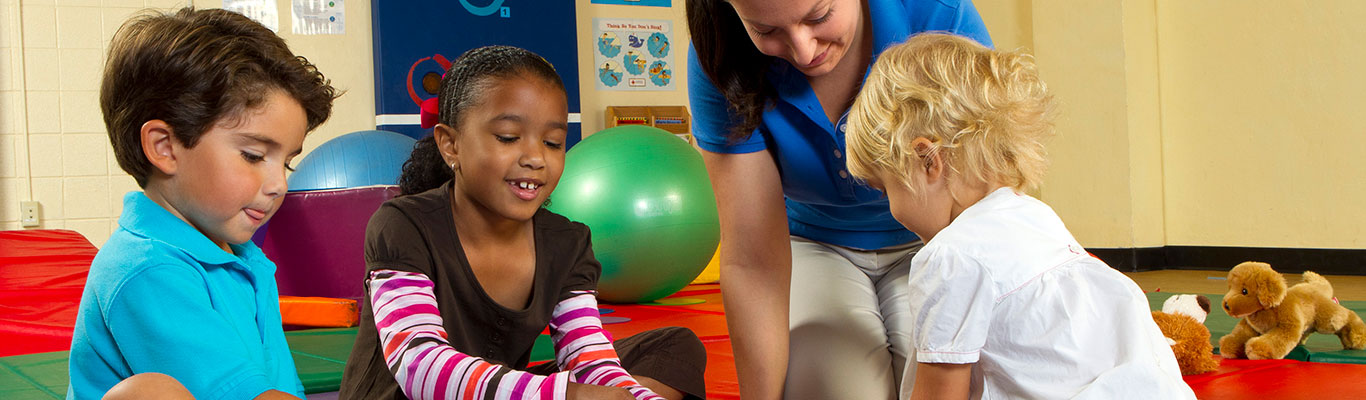 Daycare worker playing with children.