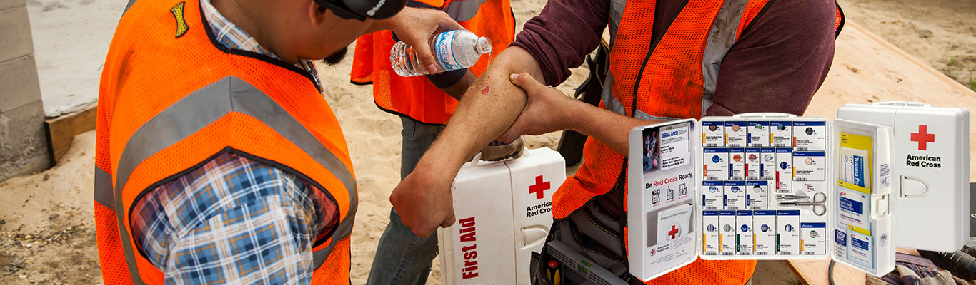 Construction worker using non-expired first aid kit and supplies to treat an arm injury.