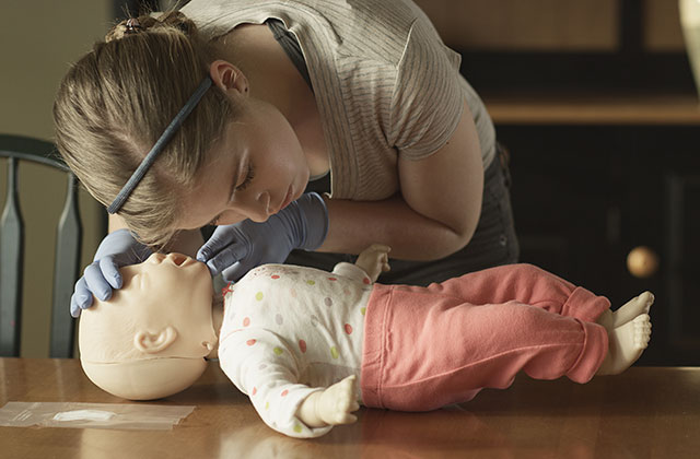 Student practicing CPR on an infant manikin.