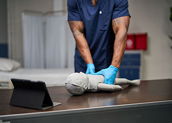 Healthcare provider practicing CPR with an Infant Elevate™ SMART Manikin.