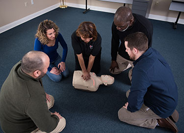 Individual performing chest compressions in a room at a Red Cross Licensed Training Provider.