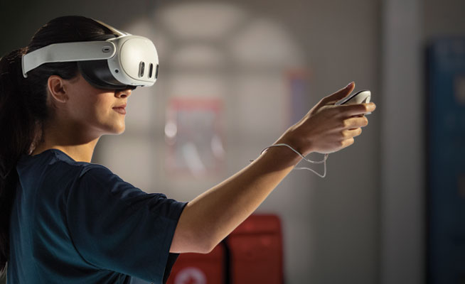 A student using a VR headset and controller to train with the Lifeguard VR App.