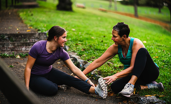 Woman providing emergency response to an individual on the ground.