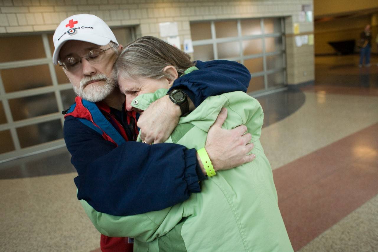Red Cross volunteer and mental health worker Walter Roberts of Manto, Minnesota, hugs Pamela Ballard at the Cheney Middle School shelter., Mental Health