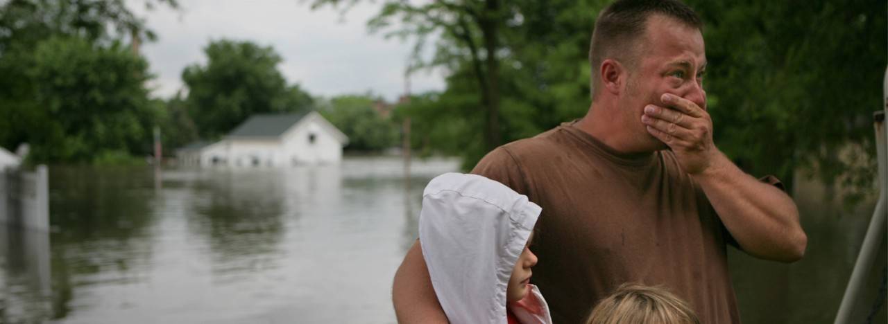 man with children looking at flood