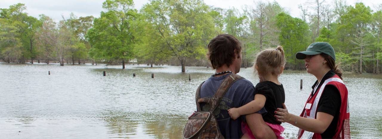 Volunteer talking to dad and child at flood scene